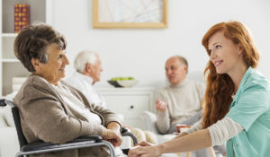 Elderly woman in nursing home with a carer