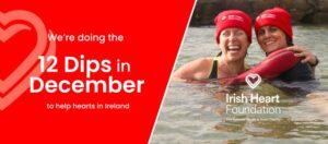 12 dips in december challenge banner with a picture of two ladies dipping in the water having fun, wearing the Irish Heart Foundation red beanie hat
