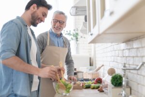 Father and adult son preparing a salad