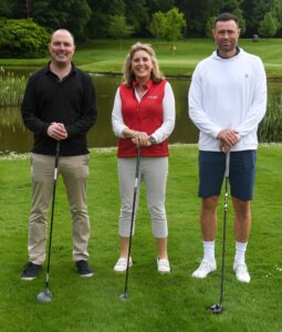 Woman and two men holding golf clubs